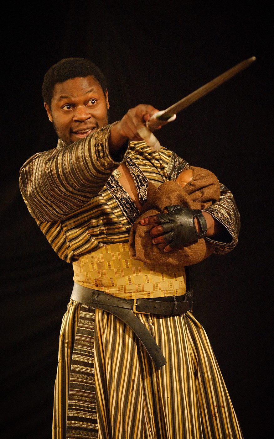 A man holds a bundle in his left arm, whilst pointing his sword at another.