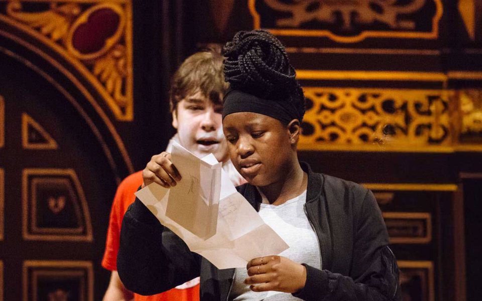 A young girl reading from a letter during an acting workshop for Much Ado About Nothing.