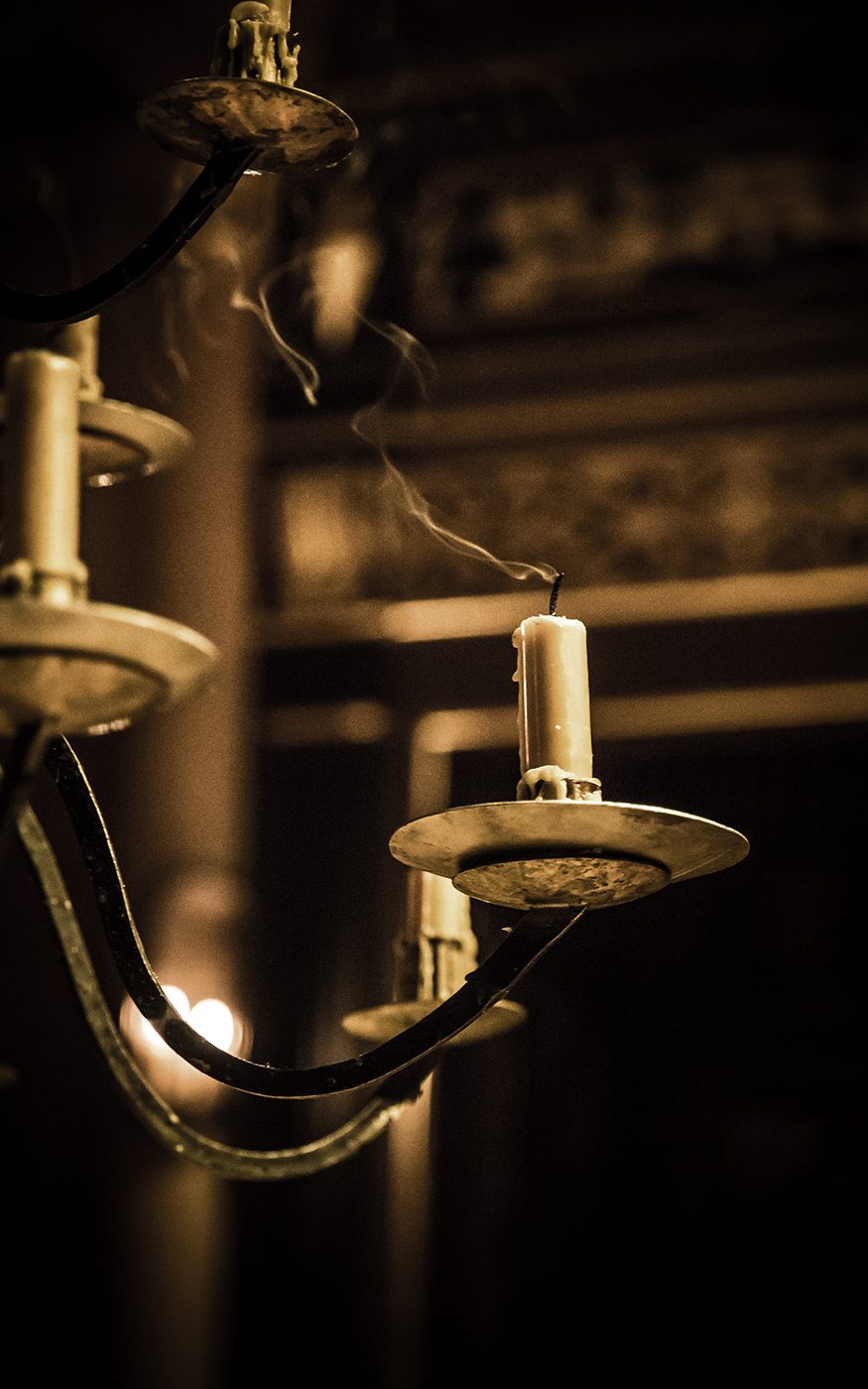 Smoke rises from a candle that has recently been extinguished.