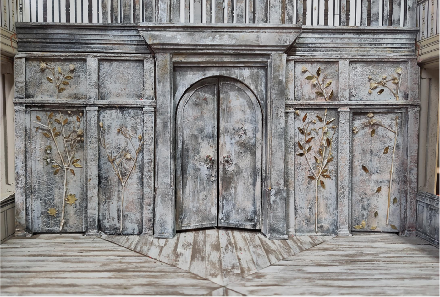Close-up of the set design of Three Sisters on a model box. The model shows the back wall of the stage, which has been clad with silver birch and adorned with trees picked out in gold relief.