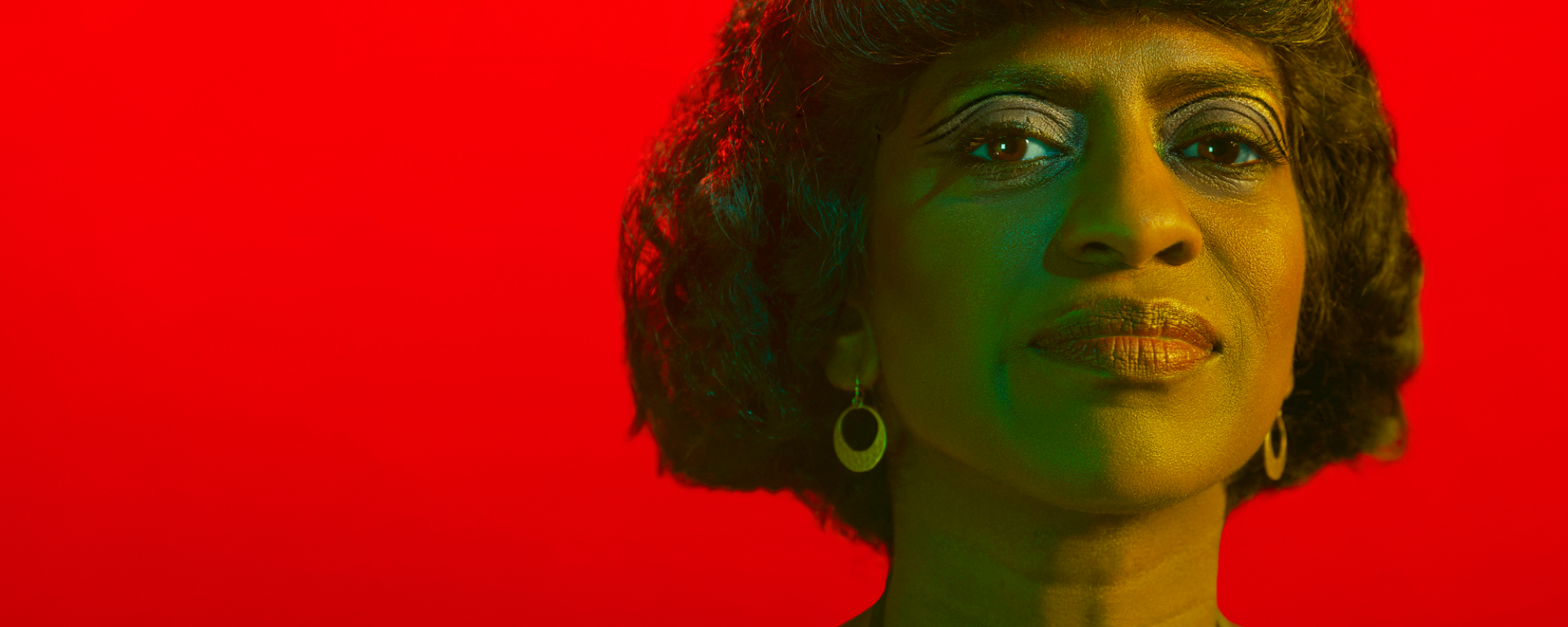 Photo of woman in front of a red background.