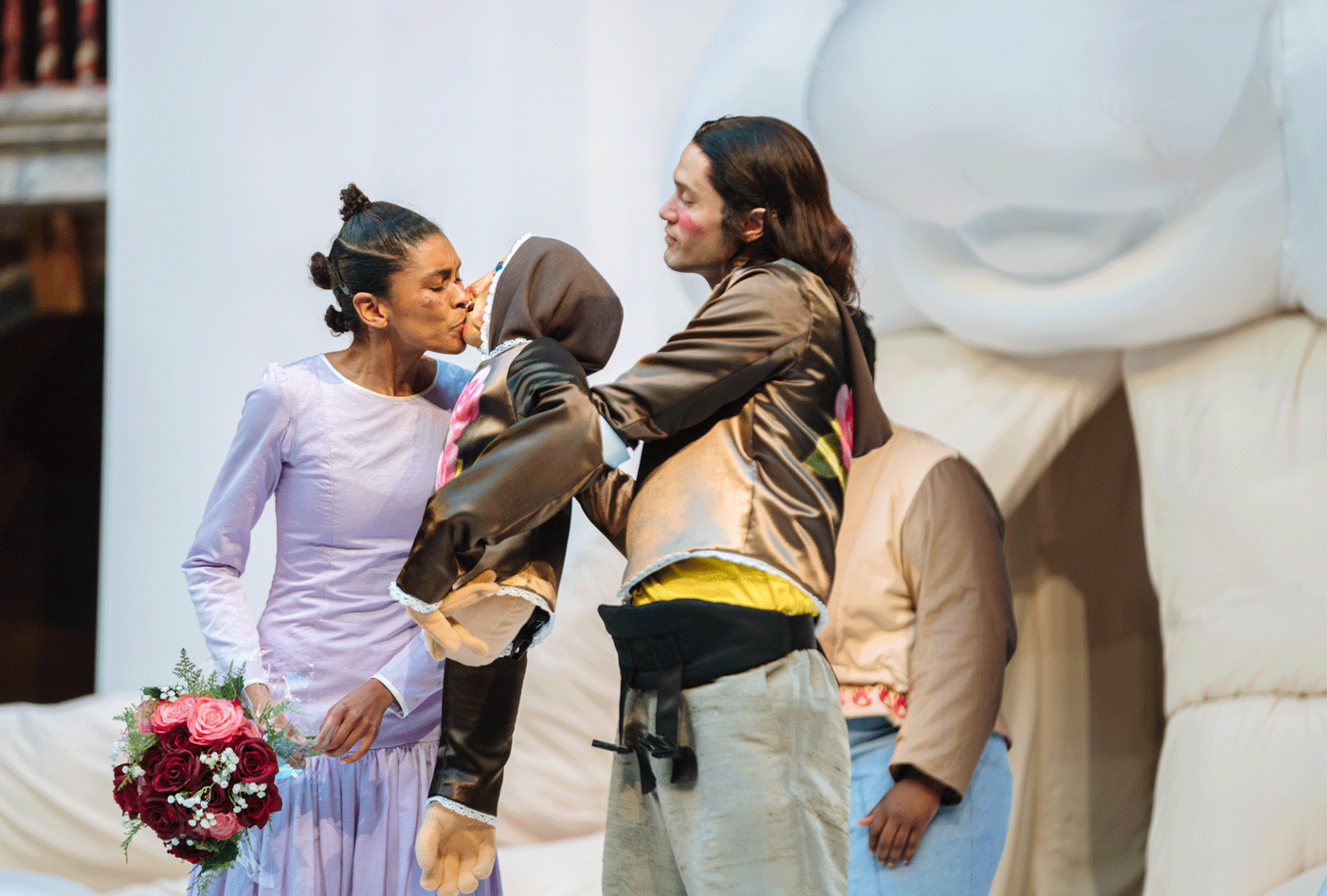 Thalissa Teixeira as Katharina holds flowers and kisses a puppet held by Andrew Leung as Petruchio. Photography by Helen Murray.